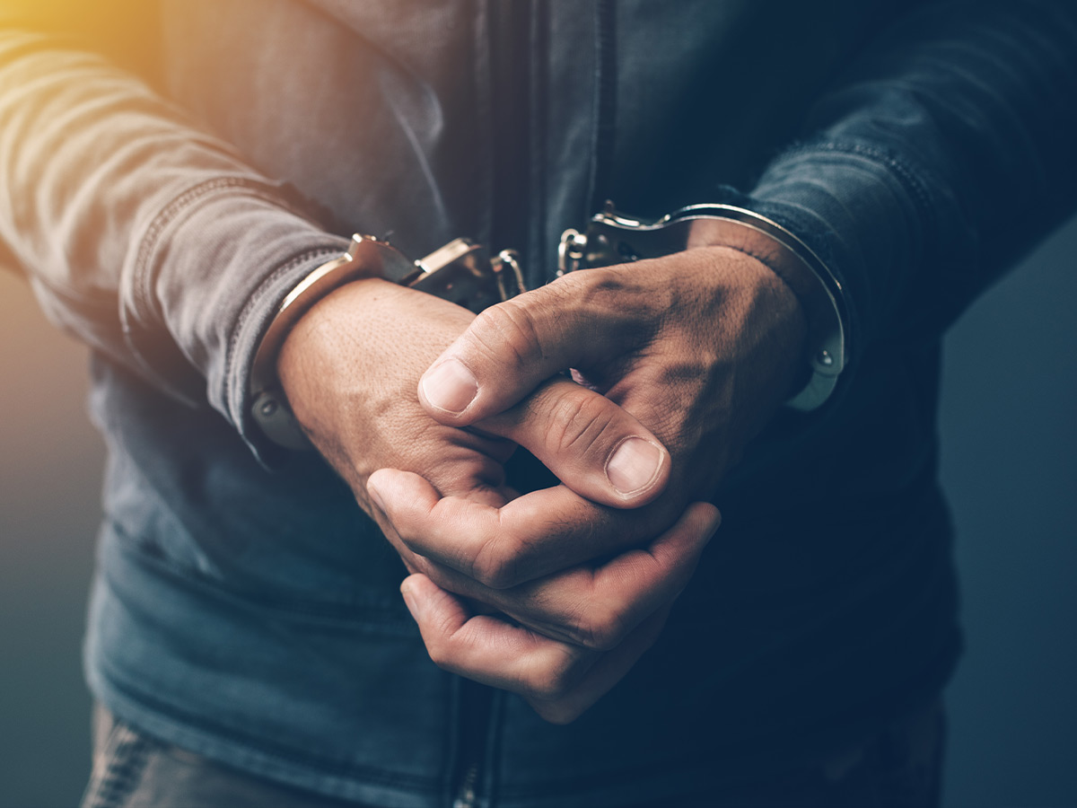 Close-up of man’s hands with handcuffs. 
