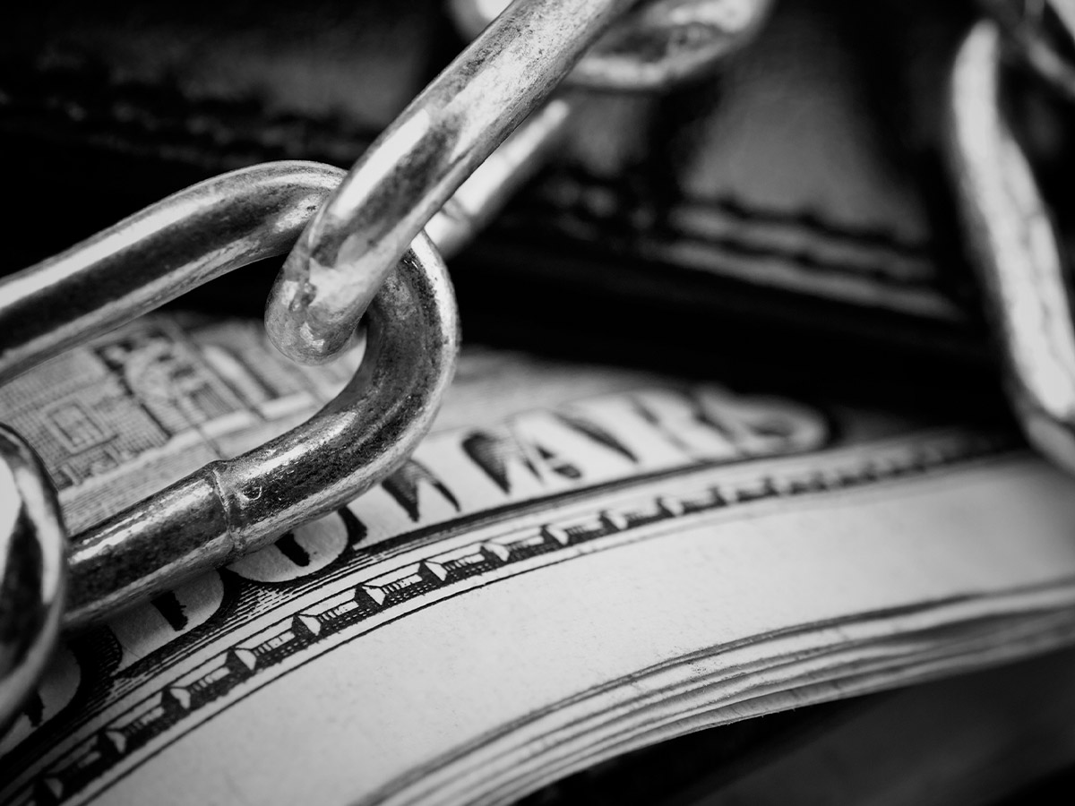 chains over a wallet filled with money