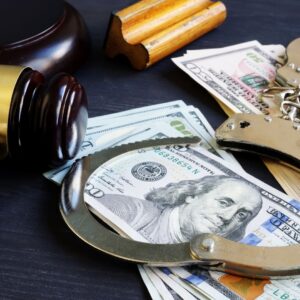 Image of handcuffs, cash, and a gavel.
