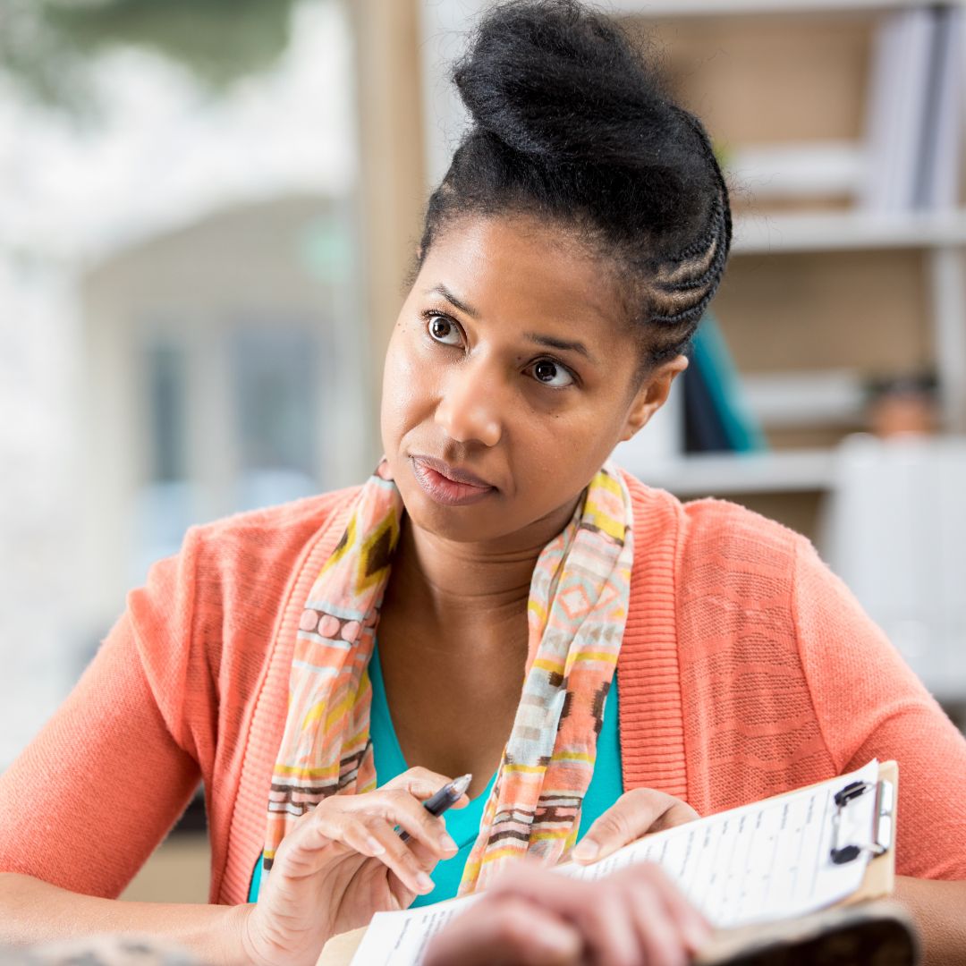 a woman talking with someone and looking at paperwork together