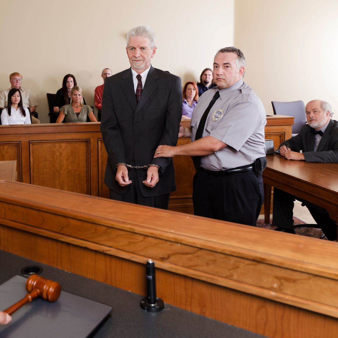 a man in handcuffs standing in front of a judge