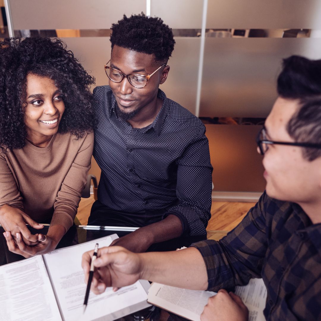 a couple looking at paperwork with a worker in an office