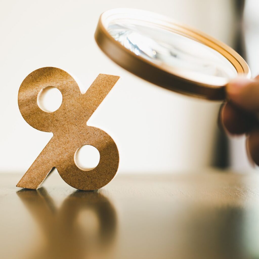 a person looking at a percentage sign with a magnifying glass