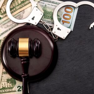 Gavel next to handcuffs and cash. 