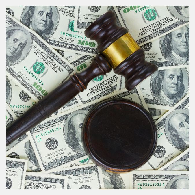 a pile of money with a gavel on top