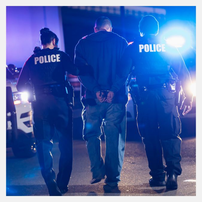 police officers escorting a person in handcuffs