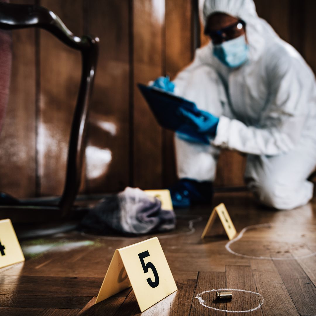 Forensic investigator documenting a crime scene with numbered markers